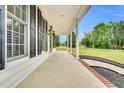 Inviting covered porch with classic columns and views of the surrounding landscape at 750 James Norris Rd, Angier, NC 27501