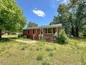 Inviting single-story brick home with a charming front porch and mature trees at 80 Dunn Rd, Louisburg, NC 27549