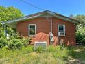 Close up of a single-story brick home featuring two windows and side entrance at 80 Dunn Rd, Louisburg, NC 27549
