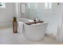 Modern bathroom featuring a freestanding tub, glass-enclosed shower, and neutral tones at 8416 Brady Pointe Rd, Fuquay Varina, NC 27526