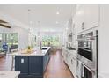 Bright kitchen with stainless steel appliances, an oversized island, and hardwood floors at 8416 Brady Pointe Rd, Fuquay Varina, NC 27526