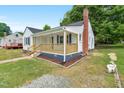 Image showcasing the left side of the house and the cozy, covered porch at 1012 Rainey St, Burlington, NC 27217