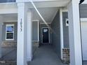 Inviting entryway featuring brick accents, gray siding, and a covered porch with white columns at 1033 Bostonian Dr, Knightdale, NC 27545