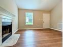 Inviting living room featuring hardwood floors, a fireplace, and natural light from a window at 106 Grange Dr, Wendell, NC 27591