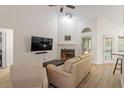 Bright living room featuring vaulted ceiling, fireplace, and hardwood floors for a cozy feel at 111 Killam Ct # 2A, Cary, NC 27513