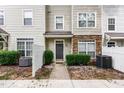Inviting townhouse entrance with stone detail, well-kept shrubs, and a neat walkway at 1220 Canyon Rock Ct # 107, Raleigh, NC 27610