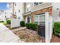 Close-up of a townhouse entrance with stone accents and manicured bushes at 1220 Canyon Rock Ct # 107, Raleigh, NC 27610