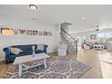 Inviting living room featuring hardwood floors, a stylish blue sofa, and staircase to the upper level at 1236 Shadow Shade, Wake Forest, NC 27587