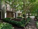 Landscaped front yard of brick townhomes features lush greenery and a welcoming walkway, adding to the curb appeal at 1314 Cornell Pl, Raleigh, NC 27607