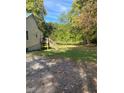 A view of the side of a house with a deck, stairs, and a lush yard at 1345 Ellis Rd, Durham, NC 27703