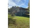 View of a two-story home featuring a spacious yard and a deck with stairs at 1345 Ellis Rd, Durham, NC 27703