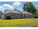 Charming brick home with a lush front yard, white columns and black shutters at 203 Marlowe Dr, Dunn, NC 28334