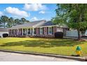 Charming brick home with a lush front yard, white columns and black shutters at 203 Marlowe Dr, Dunn, NC 28334