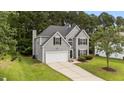 Beautiful two-story home with gray siding, black shutters, and a spacious driveway at 204 Trevor Ridge Dr, Holly Springs, NC 27540