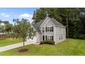 Well-maintained two-story home with gray siding, black shutters, and a lush green lawn at 204 Trevor Ridge Dr, Holly Springs, NC 27540