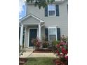 View of the home's covered front porch and garden with rose bushes at 2612 Beagle Landing Dr, Raleigh, NC 27610