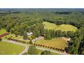 Aerial view of home featuring mature trees, surrounding acreage and a long driveway at 3123 Brassfield Rd, Creedmoor, NC 27522