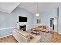 Cozy living room featuring a fireplace, hardwood floors, vaulted ceilings, and comfortable seating at 316 Waterford Dr, Clayton, NC 27520