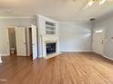Well-lit living room featuring hardwood floors, a fireplace, and a view to a bathroom at 358 Red Elm Dr, Durham, NC 27713