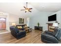 Spacious living room with vaulted ceilings, a ceiling fan, hardwood floors, and comfortable leather furniture at 400 Southerby Dr, Garner, NC 27529