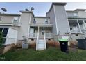 Townhome backyard featuring a small porch, outdoor access to a basement, and minimal grass at 407 Whitehall Ct, Clayton, NC 27520