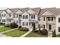 Eye-level view of the townhouses showing their well-kept lawns and tidy landscaping at 407 Whitehall Ct, Clayton, NC 27520