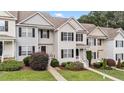Townhouse exterior showcasing a manicured lawn and tidy landscaping at 407 Whitehall Ct, Clayton, NC 27520