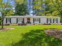 Beautiful white brick home with lush green lawn and flowering bushes creates a welcoming scene at 4112 Huckleberry Dr, Raleigh, NC 27612