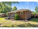 The side of a brick home with tidy landscaping and a well-maintained lawn at 464 Camp Rd, Burlington, NC 27217