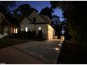 Elegant evening shot of the home's driveway leading to a garage, accented by landscape lighting at 512 Page St, Cary, NC 27511