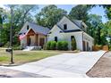Charming white home with a spacious driveway, attached garage and manicured lawn with mature trees at 512 Page St, Cary, NC 27511