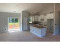 Open-concept kitchen with white cabinets, island, and sliding glass doors to the backyard at 519 Mulberry Rd, Spring Hope, NC 27882