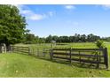 Open pasture featuring a combination of wood and metal fencing and an iron gate. Perfect for horses! at 5237 Christian Light Rd, Fuquay Varina, NC 27526