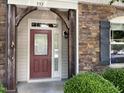 Charming front entrance with a red door, stone accents, and manicured landscaping at 532 Matheson Pl, Cary, NC 27511