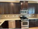 Modern kitchen with dark cabinets, stainless steel appliances, and granite countertops at 532 Matheson Pl, Cary, NC 27511