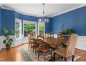 Elegant dining room with large windows, wood floors, and stylish light fixture at 6 Beltre Ct, Durham, NC 27705