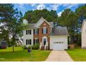 Charming two-story home with a brick facade, white siding, a well-manicured lawn and an attached garage at 805 Penncross Dr, Raleigh, NC 27610