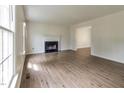 Bright living room features hardwood floors, a fireplace, and natural light from a large window at 805 Penncross Dr, Raleigh, NC 27610
