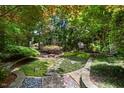 Picturesque backyard garden with stone pathways, lush greenery, and tranquil seating area at 81502 Alexander, Chapel Hill, NC 27517