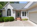 Close up of front of home showing a glass front door, potted plants and the two car garage at 81502 Alexander, Chapel Hill, NC 27517