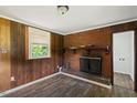 Living room with hardwood floors, a brick fireplace, and a window providing natural light and a cozy feel at 995 Shawtown Rd, Lillington, NC 27546