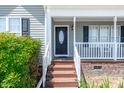 Inviting front porch with decorative black door and white railing at 104 Jj Dr, Benson, NC 27504