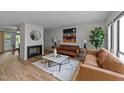 Bright living room with a decorative fireplace, two leather sofas and a stylish area rug at 109 Virginia Pl, Cary, NC 27513