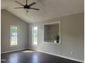 Bright living room with vaulted ceilings, modern ceiling fan and large windows offering plenty of natural light at 12 Linsey Ct, Lillington, NC 27546