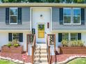 Close-up of the home's front door and entryway with landscaping and flower boxes at 1220 Sherbrooke Ct, Raleigh, NC 27612