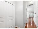 Bright hallway with hardwood floors, neutral paint, closet, and doorways leading to other rooms at 1231 Silver Beach Way, Raleigh, NC 27606