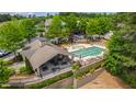 Aerial view of a community pool, grilling station, and lounge area surrounded by lush greenery at 1231 Silver Beach Way, Raleigh, NC 27606