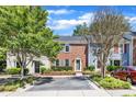 Street view of traditional townhouses with brick and siding, front gardens, and parking spots at 1344 Baez St, Raleigh, NC 27608