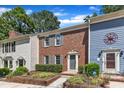 Brick townhouse with gray shutters and trim, complemented by lush front yard landscaping and an ADT security sign at 1344 Baez St, Raleigh, NC 27608