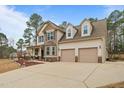 Beautiful two-story home with a two-car garage, covered porch, and long driveway on a sunny day at 138 Tramway Cir, Angier, NC 27501